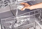 Photo of a person cleaning a dishwasher