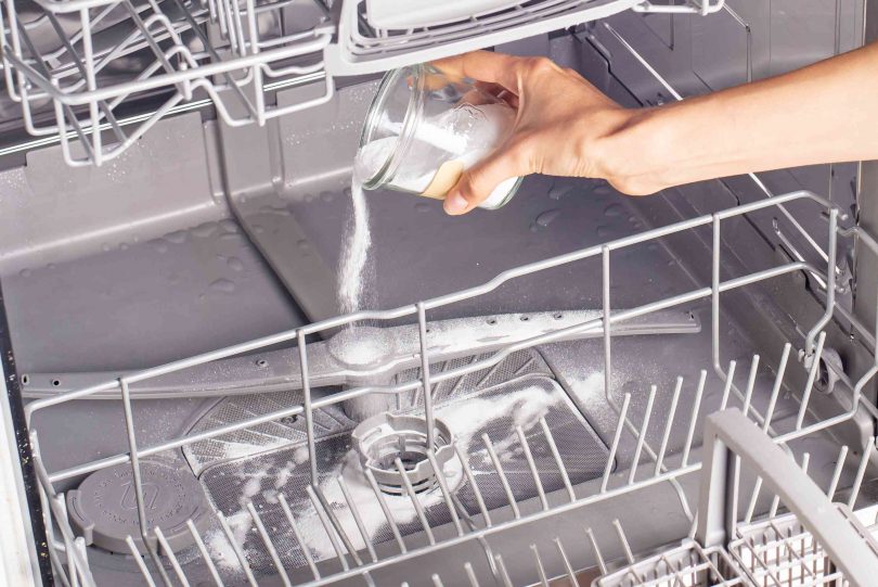 Photo of a person cleaning a dishwasher